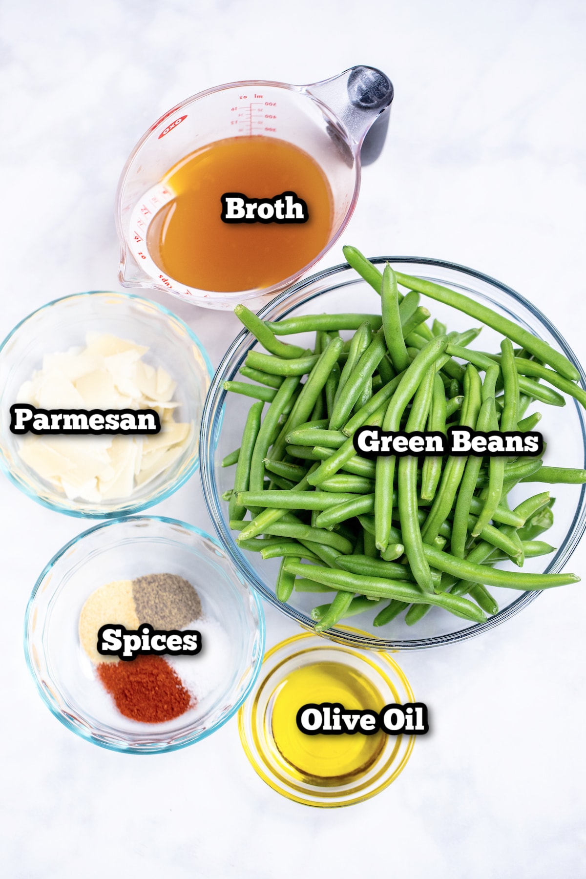 Individual ingredients for instant pot green beans on a marble table.