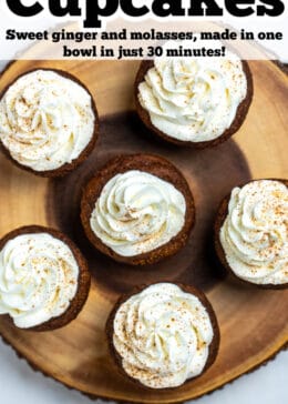 Pinterest pin with gingerbread cupcakes topped with frosting on a wooden cutting board and other cupcakes.