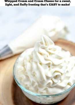 Pinterest pin with whipped cream cheese frosting piped into a glass bowl next to a piping bag on a wooden cutting board.