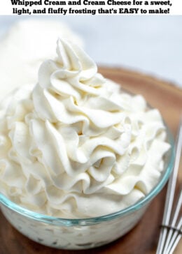 Pinterest pin of whipped cream cheese frosting piped into a glass bowl next to a whisk on a wooden cutting board.