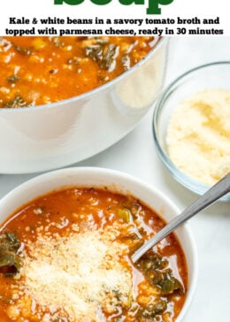 Pinterest pin with a bowl of kale and white bean soup with a spoon in the soup, next to a dish of parmesan cheese and in front of a larger pot of soup.