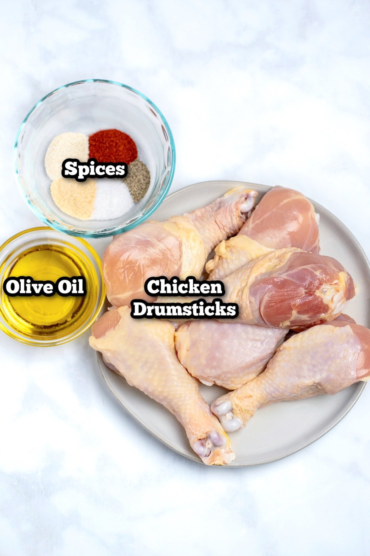 Individual ingredients for air fryer chicken drumsticks on a table.