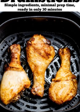 Pinterest pin with three chicken drumsticks in an air fryer.