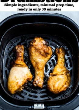 Pinterest pin with three chicken drumsticks in an air fryer.