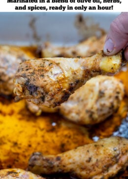 Pinterest pin with a baking dish with cooked chicken drumsticks covered in marinade.