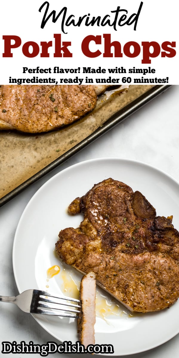 A marinated pork chop on a plate with a fork holding a slice of chop, next to a sheet pan with other cooked pork chops.