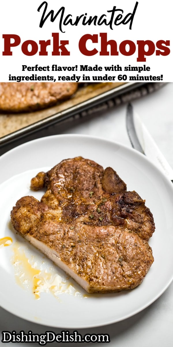 A marinated pork chop on a plate, next to a sheet pan with other cooked pork chops.