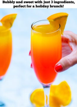 Pinterest pin with a hand holding a prosecco mimosa in front of a small bowl of orange slices.