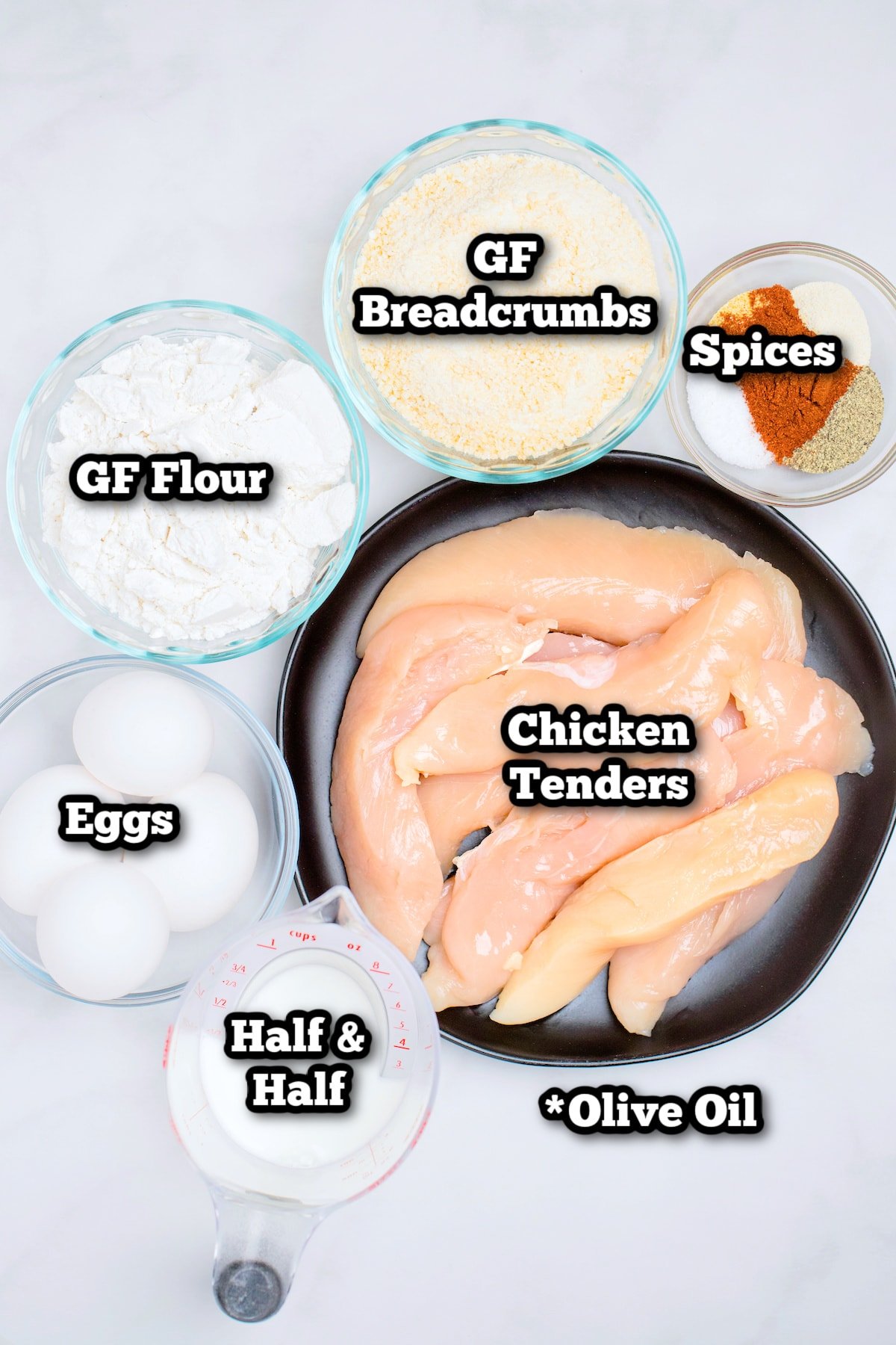 Individual ingredients for baked chicken tenders on a marble table.
