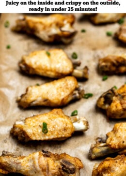 Pinterest pin with instant pot chicken wings on a sheet pan lined with parchment paper topped with green onions.
