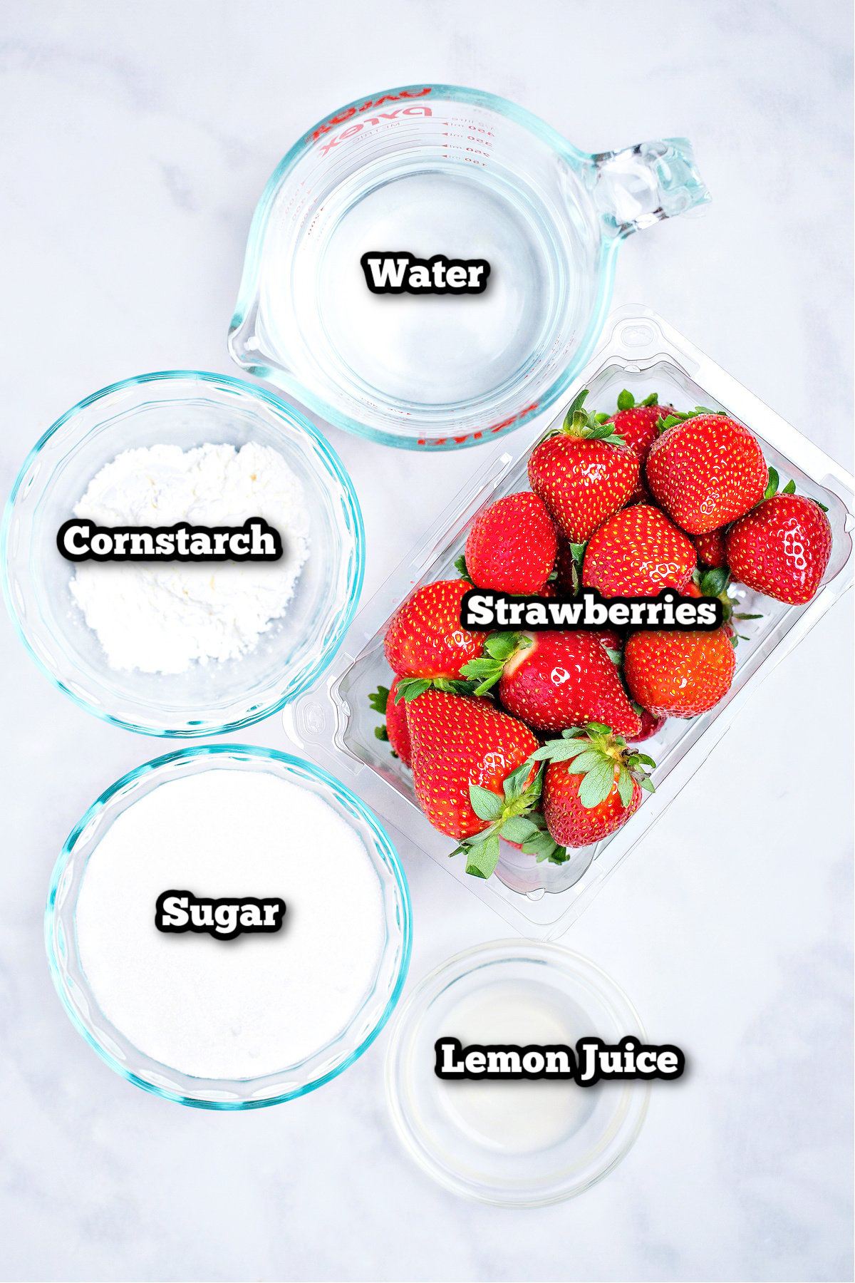 Individual ingredients for strawberry cake filling on a table.