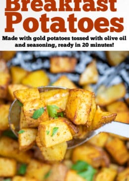 A spoon lifting air fryer breakfast potatoes out of an air fryer basket.