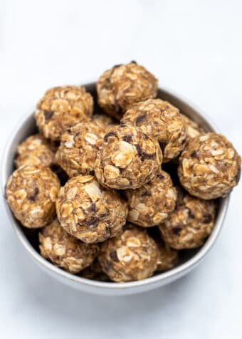 A bowl full of peanut butter oat balls on a table.