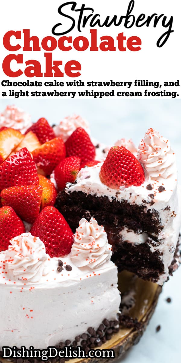 Pinterest pin with a strawberry chocolate cake on a wooden cake stand, decorated with mini chocolate chips and frosting dolloped on top with fresh whole strawberries and a piece being lifted out.