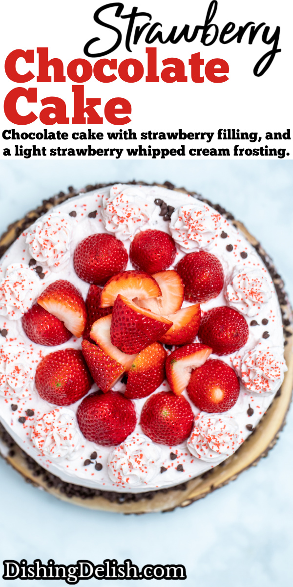Pinterest pin with strawberry chocolate cake on a wooden cake stand, decorated with mini chocolate chips and frosting dolloped on top with fresh whole strawberries.