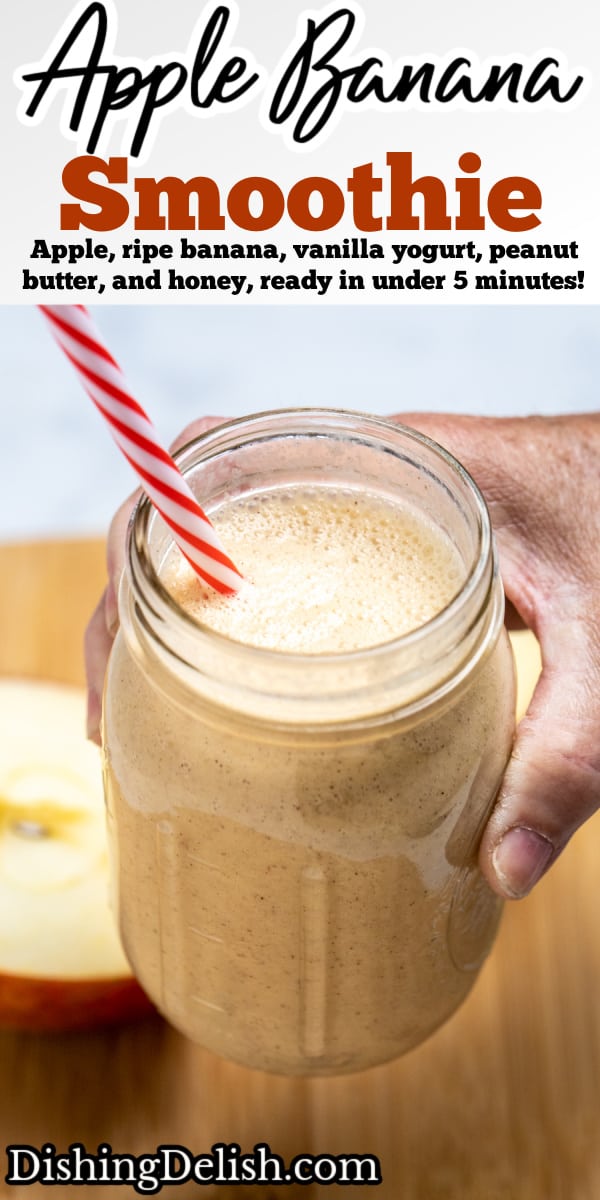 Pinterest pin with a hand holding an apple banana smoothie in a mason jar with a straw above a wooden cutting board with an apple cut in half behind it.