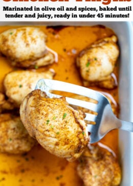 Pinterest pin with a baking dish of fully cooked chicken thighs sitting in chicken broth, with a spatula lifting one up, topped with seasoning and fresh chives.