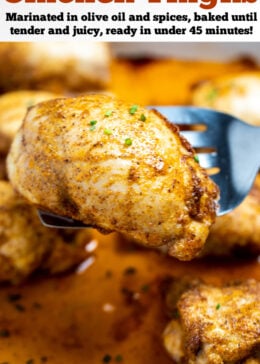 Pinterest pin with a baking dish of fully cooked chicken thighs sitting in chicken broth, with a spatula lifting one up, topped with seasoning and fresh chives.