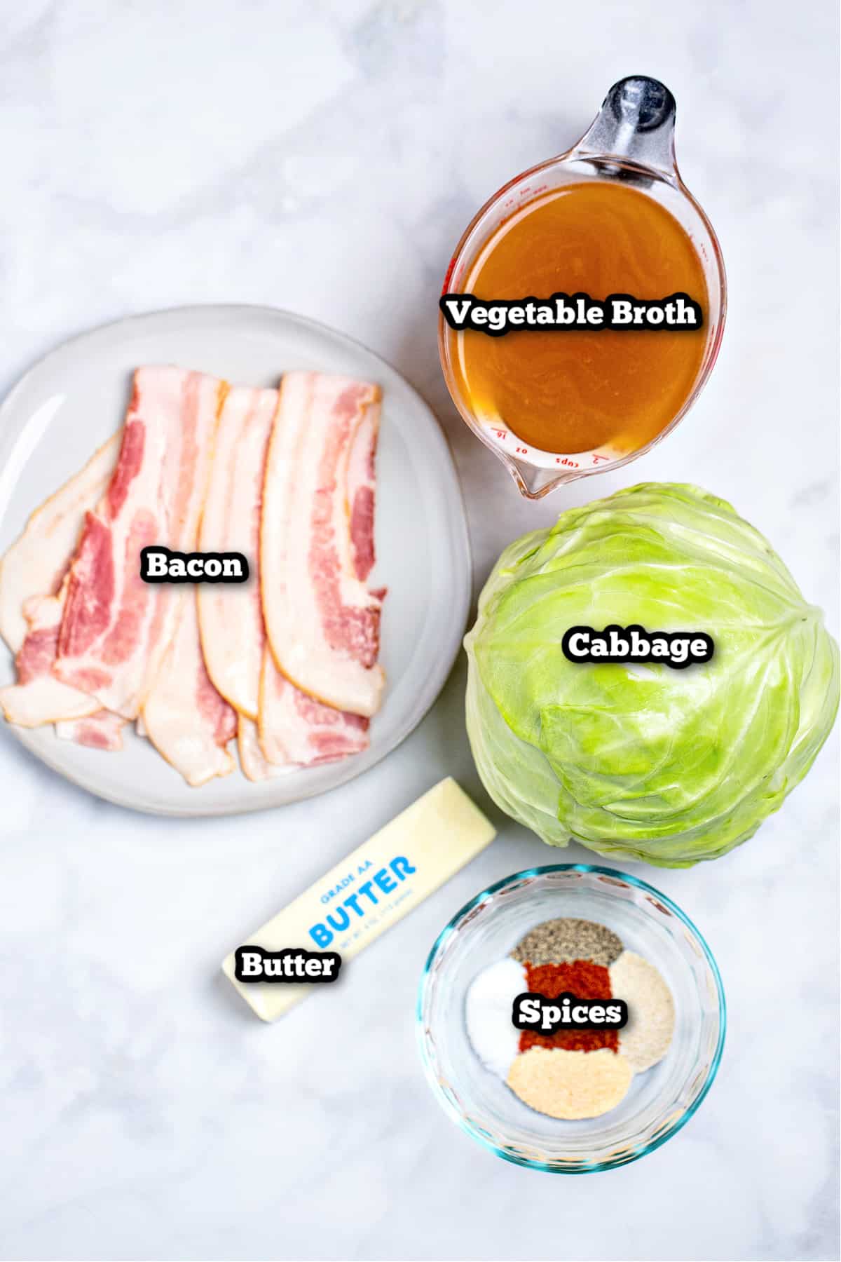 Individual ingredients for crockpot cabbage on a marble table.