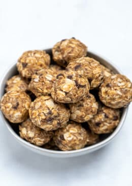 A bowl with peanut butter oat balls on a table.