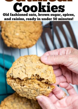 Pinterest pin with hands breaking a cookie in half over a cooling rack of gluten free oatmeal cookies.