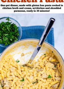 Pinterest pin with a dutch oven resting on a kitchen towel on the table, full of garlic parmesan chicken pasta topped with fresh parsley, with a spoon resting in the pot where some pasta has already been scooped out.