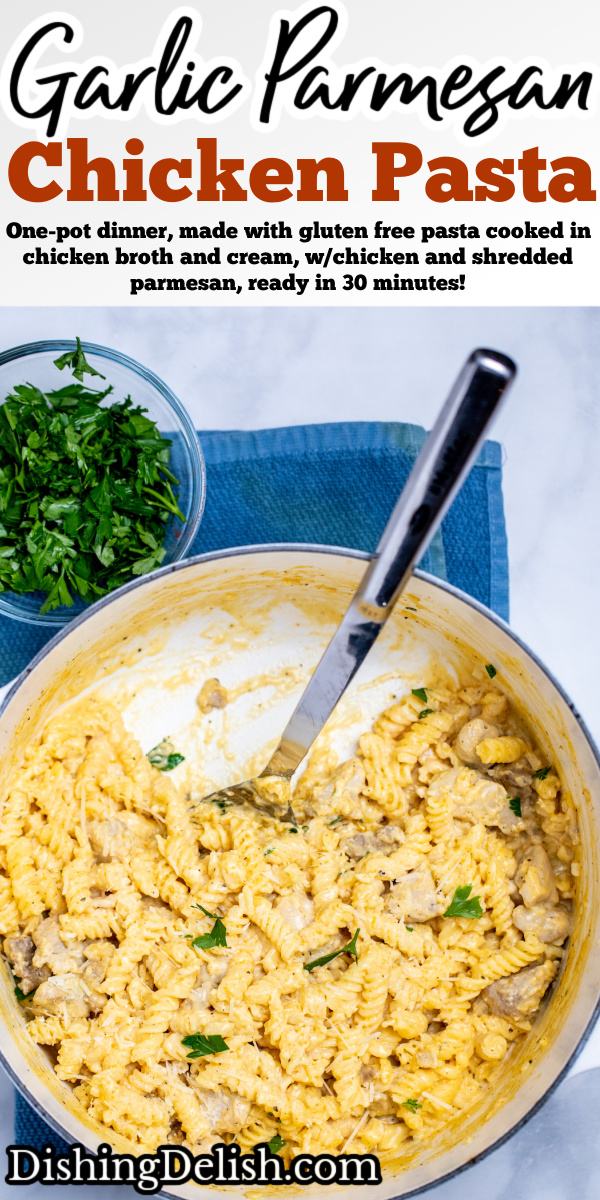 Pinterest pin with a dutch oven resting on a kitchen towel on the table, full of garlic parmesan chicken pasta topped with fresh parsley, with a spoon resting in the pot where some pasta has already been scooped out.