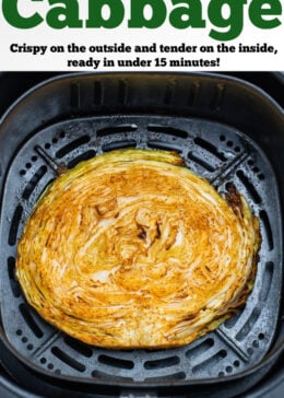 Pinterest pin with a fully cooked cabbage steak inside of an air fryer basket.