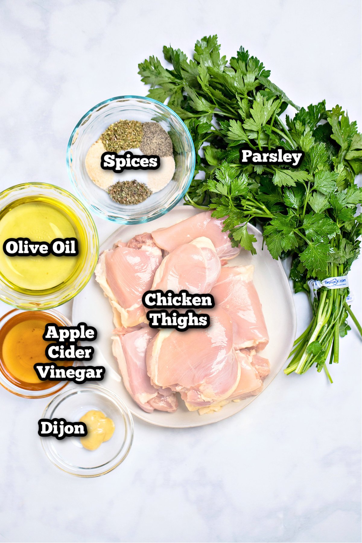 Individual ingredients for marinated chicken thighs on a table.