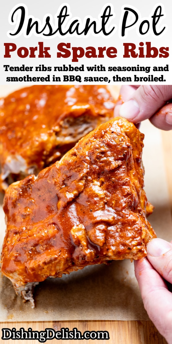 Pinterest pin with two hands lifting up a section of pork spare ribs smothered in bbq sauce from a piece of parchment paper on a cutting board, with more sections of ribs in the background.
