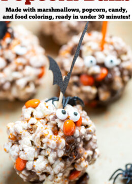 Pinterest pin with a Halloween popcorn ball on a sheet pan surrounded by orange sprinkles and spiders.