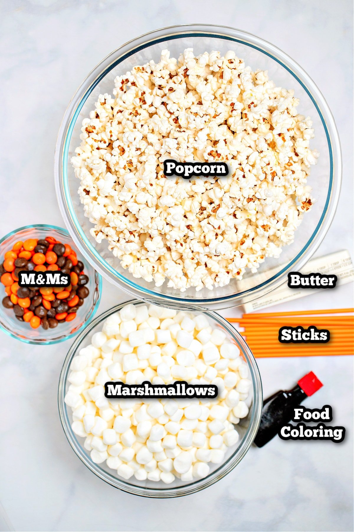 Individual ingredients for halloween popcorn balls on a table.