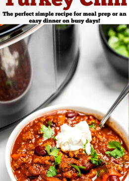 Pinterest pin with a bowl of turkey chili in front of a crockpot topped with fresh cilantro and sour cream.