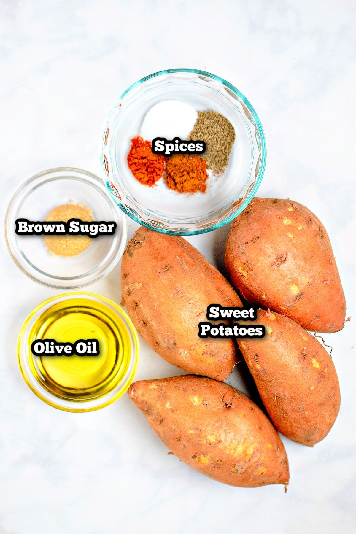 Individual ingredients for roasted sweet potato cubes on a table.