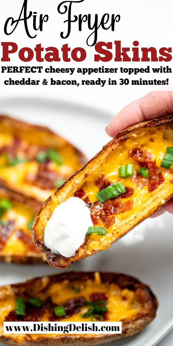 Pinterest pin with a hand holding a potato skin with sour cream above a plate of more air fryer potato skins.