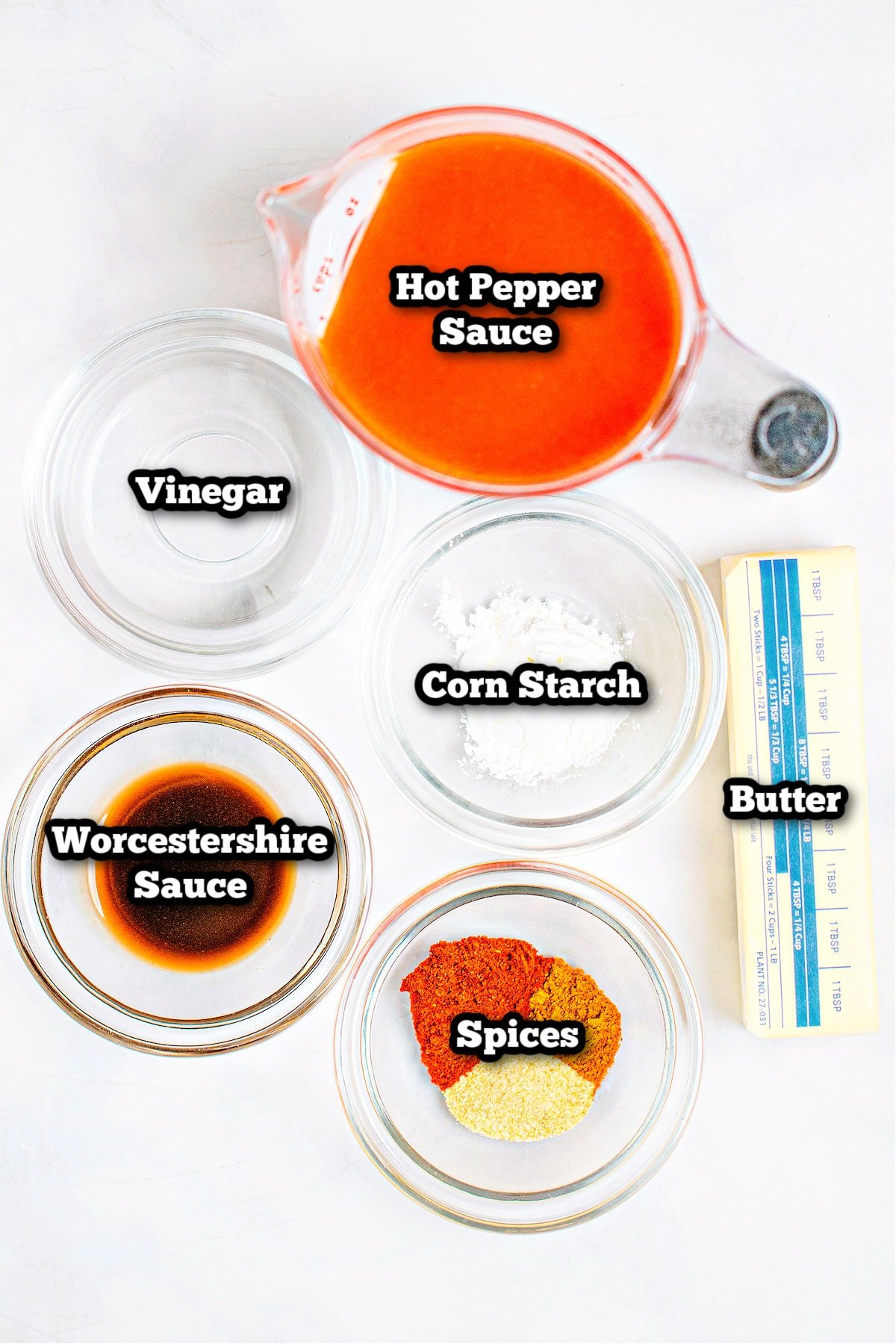 Individual ingredients for buffalo wing sauce on a table.