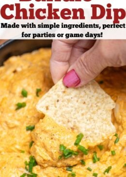 Pinterest pin with a bowl of slow cooker buffalo chicken dip topped with chives, with a hand dipping a chip into the dip.