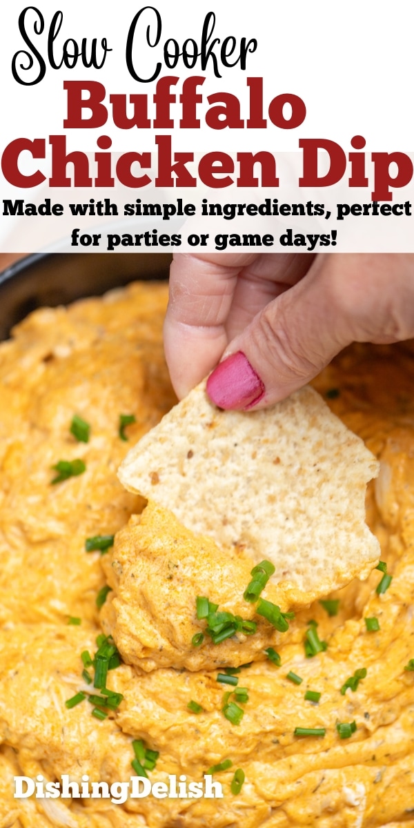 Pinterest pin with a bowl of slow cooker buffalo chicken dip topped with chives, with a hand dipping a chip into the dip.