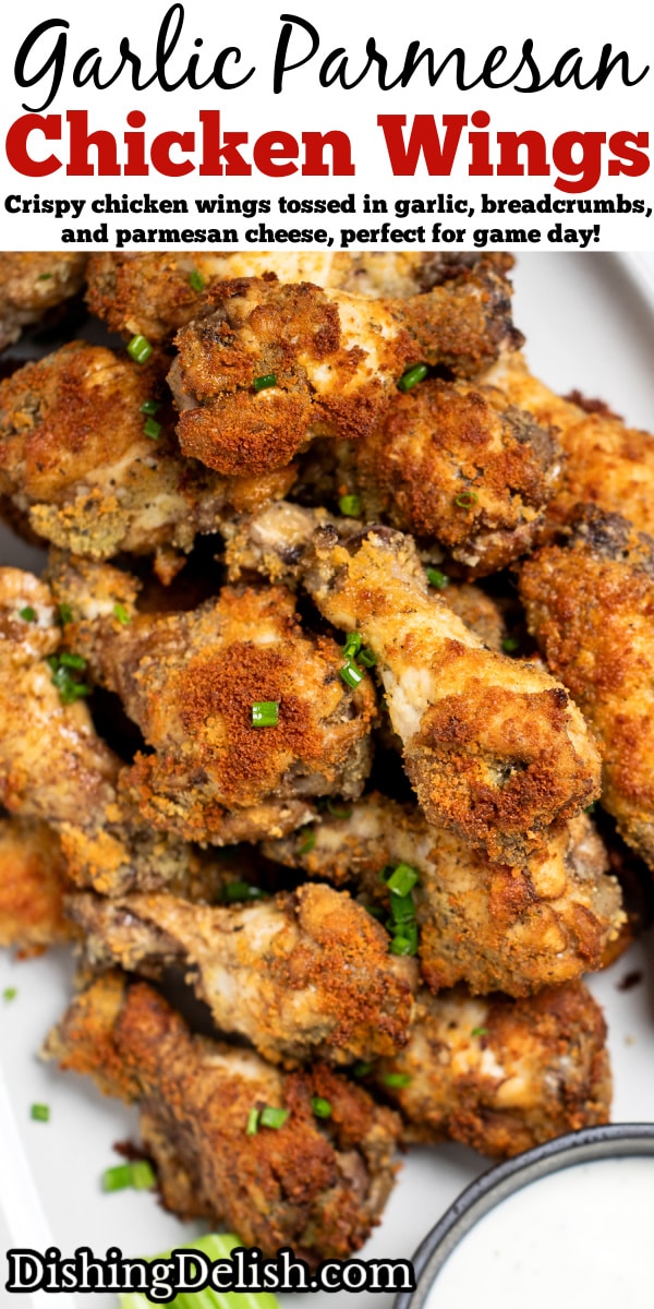 Pinterest pin with a plate with garlic parmesan wings in a pile topped with chives and next to a bowl of ranch and celery.