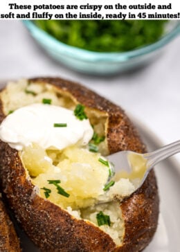 Pinterest pin with a fork scooping some baked potato topped with butter, chives, and sour cream, with a small bowl of chives behind the plate.