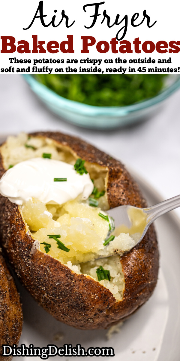 Pinterest pin with a fork scooping some baked potato topped with butter, chives, and sour cream, with a small bowl of chives behind the plate.