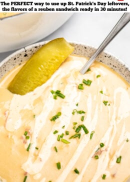 Pinterest pin with a spoon in a bowl of reuben soup on a table, topped with a pickle and a drizzle of Thousand Island dressing and chopped chives, in front of a dutch oven of soup.
