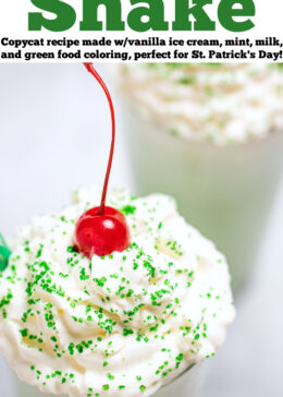 Pinterest pin with a tall glass of shamrock shake topped with whipped cream, sprinkles, and a cherry on top, and another shamrock shake in the background.