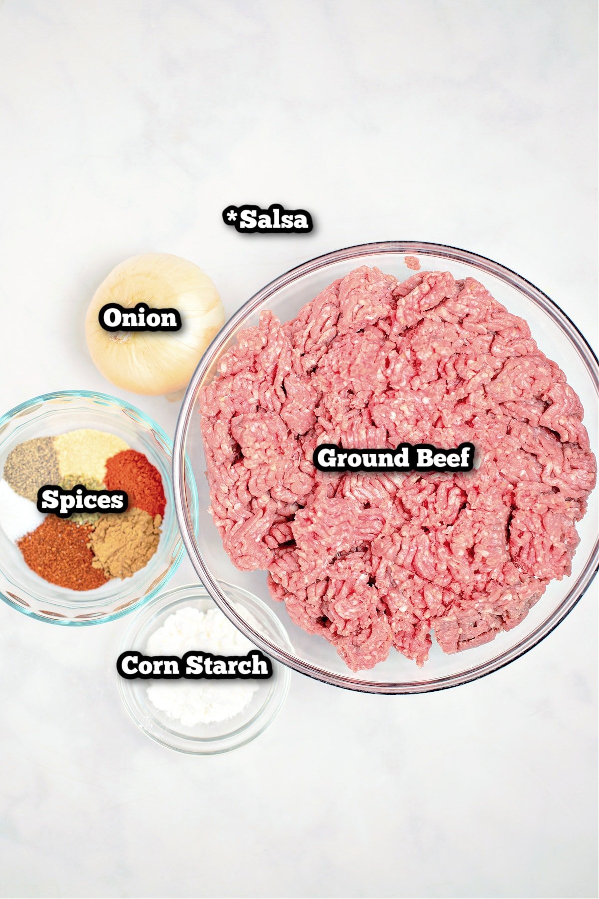 Individual ingredients for slow cooker taco meat on a table.