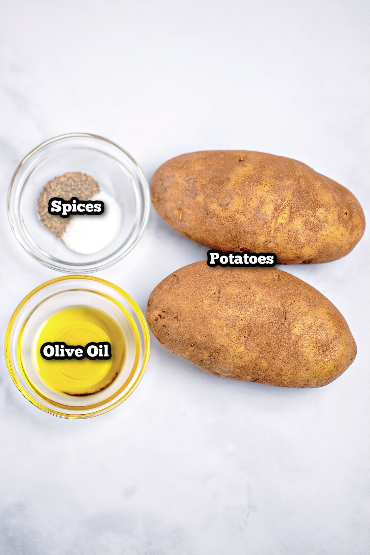 Individual ingredients for air fryer baked potatoes on a table.