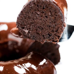 A piece of cake being lifted up from the chocolate brownie bundt cake.