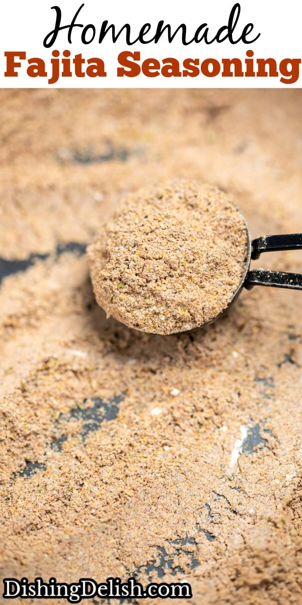 Pinterest pin with a closeup in a bowl of fajita seasoning, with a tablespoon full of seasoning resting in the bowl.