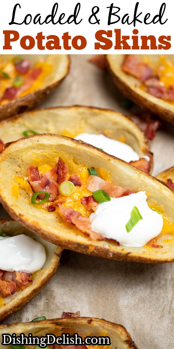 Pinterest pin with loaded potato skins topped with cheese, bacon, green onions, and sour cream on a sheet pan.