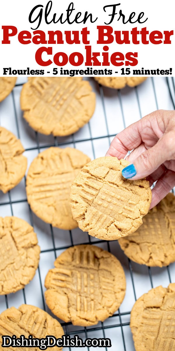 Pinterest pin with a hand holding a gluten free peanut butter cookie over a cookie rack of cooling cookies.