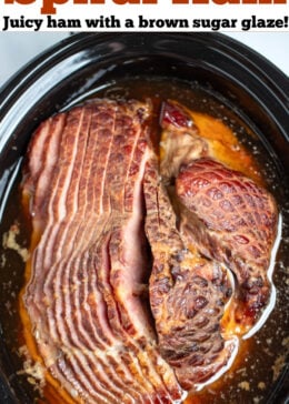 Pinterest pin with a slow cooker full of spiral ham in its cooking liquid.